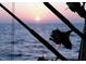 Several fishing rods in rod holders are silhouetted against a sunset on the water at 3543 Rockaway Dr, Holiday, FL 34691