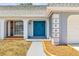 Inviting home entrance featuring a bright blue door and lovely landscape detail at 3543 Rockaway Dr, Holiday, FL 34691