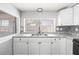 Kitchen features white cabinets, granite countertops, and stainless steel sink at 3543 Rockaway Dr, Holiday, FL 34691