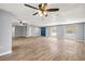 Bright living room with wood-look tile floors, ceiling fans, and a large blue front door at 3543 Rockaway Dr, Holiday, FL 34691