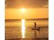 Water view of paddle boarder on calm sea as the sun sets in the background at 3543 Rockaway Dr, Holiday, FL 34691