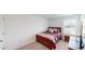 Cozy bedroom with a bed, bedside table, and a window providing natural light at 35646 Eastbrook Ave, Zephyrhills, FL 33541