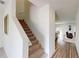 Inviting hallway with wood-look flooring, carpeted stairs, and an open view into the living area at 35646 Eastbrook Ave, Zephyrhills, FL 33541