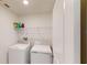 Bright laundry room with washer, dryer, and shelving for convenient storage at 35646 Eastbrook Ave, Zephyrhills, FL 33541