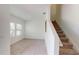 Open living area with large windows, neutral carpet, and stairs to the upper level at 35646 Eastbrook Ave, Zephyrhills, FL 33541