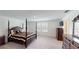 Spacious main bedroom with four-poster bed, large windows, and sleek, modern furniture at 35646 Eastbrook Ave, Zephyrhills, FL 33541