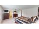 Expansive main bedroom with four-poster bed, sleek furniture, and carpet flooring at 35646 Eastbrook Ave, Zephyrhills, FL 33541