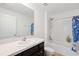 Bathroom with a single sink vanity, mirror, toilet, and shower with tub at 36727 Spanish Rose Dr, Dade City, FL 33525