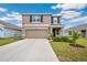 Two-story home with neutral paint, a two-car garage and black shutters at 36727 Spanish Rose Dr, Dade City, FL 33525
