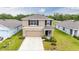 Inviting two-story home with a simple landscape design featuring a neutral color palette and attached garage at 36727 Spanish Rose Dr, Dade City, FL 33525