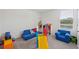 Bright and playful playroom with soft carpet, blue modular seating, and colorful toys at 36727 Spanish Rose Dr, Dade City, FL 33525