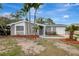 Beautiful home with palm trees, gray exterior, stone accents, and a driveway leading to a garage at 4111 Stratfield Dr, New Port Richey, FL 34652