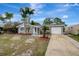 Charming single-story home featuring a well-manicured lawn, palm trees, and a driveway leading to an attached garage at 4111 Stratfield Dr, New Port Richey, FL 34652