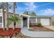 Inviting home entrance with a paved walkway, stone accents, and lush landscaping at 4111 Stratfield Dr, New Port Richey, FL 34652