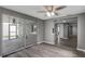 Open living room with wood-look floors, adjacent to a sunroom and a hallway at 4111 Stratfield Dr, New Port Richey, FL 34652