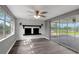 Bright living room features a decorative fireplace, fan, and sliding glass doors to a screened patio at 4111 Stratfield Dr, New Port Richey, FL 34652