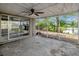 Screened lanai area with tile floor and picturesque lake views, ceiling fan, and sliding glass door at 4111 Stratfield Dr, New Port Richey, FL 34652
