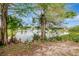 Picturesque pond view showcases the tranquil waterfront setting with mature trees and clear blue skies at 4111 Stratfield Dr, New Port Richey, FL 34652