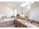 Bathroom featuring double sinks, granite counters, and a large soaking tub at 5253 1St N Ave, St Petersburg, FL 33710