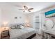 Bright bedroom with ceiling fan, television, vanity, and large bed with patterned comforter and decorative pillows at 5253 1St N Ave, St Petersburg, FL 33710
