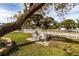 Inviting front yard with mature trees, a decorative fence, and an outdoor seating area at 5253 1St N Ave, St Petersburg, FL 33710