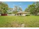 Home featuring a large backyard, white fence, mature trees and a storage shed at 6231 Massey Rd, Zephyrhills, FL 33542