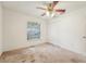 Bedroom with ceiling fan and window next to a closet with folding doors at 6231 Massey Rd, Zephyrhills, FL 33542