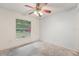 Bedroom with ceiling fan and window overlooking the yard at 6231 Massey Rd, Zephyrhills, FL 33542