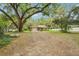 Wide exterior view showcasing home's architecture and spacious, treed front yard at 6231 Massey Rd, Zephyrhills, FL 33542