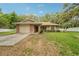 Charming brick home with a well-maintained lawn, a red door, and an attached garage at 6231 Massey Rd, Zephyrhills, FL 33542