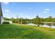 Spacious backyard featuring lush green grass and a tranquil pond view at 6674 Cobble Bliss St, Zephyrhills, FL 33541