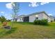 Large backyard with lush grass and view of the home's exterior at 6674 Cobble Bliss St, Zephyrhills, FL 33541