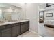 Bathroom with dual vanity, walk-in shower and bedroom access at 6674 Cobble Bliss St, Zephyrhills, FL 33541
