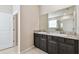 Bathroom with double vanity, granite countertop and large mirror at 6674 Cobble Bliss St, Zephyrhills, FL 33541