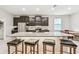 Modern kitchen features a large island with granite countertops and barstool seating at 6674 Cobble Bliss St, Zephyrhills, FL 33541