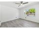 Bright bedroom featuring wood-look floors, a ceiling fan, and a view of the pool at 706 Caliente Dr, Brandon, FL 33511