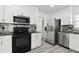 Spacious updated kitchen with stainless steel appliances, gray counters, and white cabinets at 706 Caliente Dr, Brandon, FL 33511