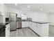 Gourmet kitchen featuring stainless appliances, gray countertop, white cabinets, and wood-look tile at 706 Caliente Dr, Brandon, FL 33511