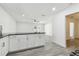 Open floor plan featuring living room, dining room, and kitchen with white walls and light gray floors at 706 Caliente Dr, Brandon, FL 33511