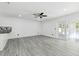 Open living area featuring light gray floors, white walls and door out to the pool and patio at 706 Caliente Dr, Brandon, FL 33511