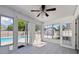 Bright sunroom with tile floors, a ceiling fan, and sliding glass doors leading to the pool at 706 Caliente Dr, Brandon, FL 33511