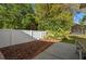 Landscaped backyard features a white privacy fence, mulch bed, and an extended patio at 775 Brittany Park Blvd, Tarpon Springs, FL 34689