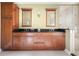Bathroom featuring double sinks, dark countertops, wooden cabinets, and a glass shower at 775 Brittany Park Blvd, Tarpon Springs, FL 34689
