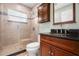Bathroom featuring a walk-in shower, granite countertop and wood cabinet at 775 Brittany Park Blvd, Tarpon Springs, FL 34689