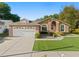 Charming single-story home featuring a manicured lawn and a two-car garage at 775 Brittany Park Blvd, Tarpon Springs, FL 34689