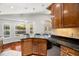 Kitchen showcasing granite counters, wood cabinetry, and stainless steel dishwasher at 775 Brittany Park Blvd, Tarpon Springs, FL 34689