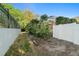 Side yard with white fence and green foliage at 775 Brittany Park Blvd, Tarpon Springs, FL 34689