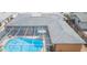 Aerial view of a home with a screened-in pool area, gray roof, and well-maintained landscaping at 8215 Hixton Dr, Port Richey, FL 34668