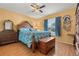 Sunlit bedroom with blue patterned bedding, wooden furnishings, and natural light from the window at 8215 Hixton Dr, Port Richey, FL 34668
