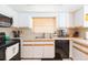 Clean kitchen with white cabinets, black appliances, and tile backsplash by double sink at 8215 Hixton Dr, Port Richey, FL 34668